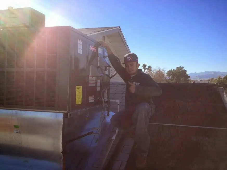 HVAC technician performing AC Tune-Up on a rooftop unit in Saraland